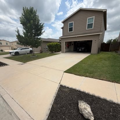 Freshly cleaned driveway and walkway in front of a New Braunfels home