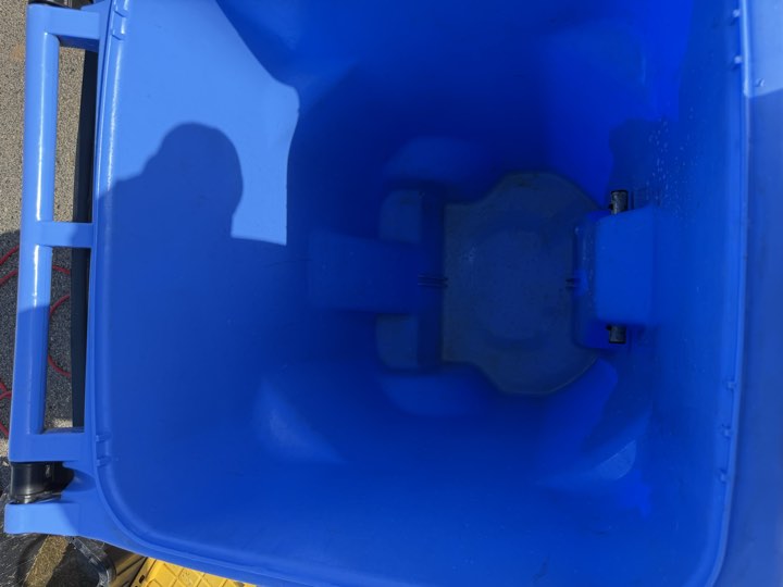 Blue trash bin interior after deep cleaning and sanitizing